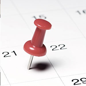 A pushpin sticking into a calendar